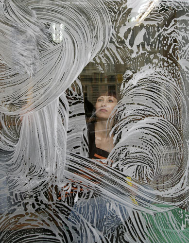 Gallery November 7 2008: Warsaw, Poland: A woman cleans a window at an antiquarian bookshop