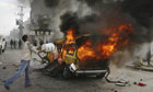 A Palestinian tries to extinguish a fire in a car