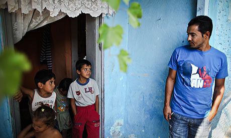 Romica Raducanu glances at his children outside his house in the  village of Barbulesti, Romania.