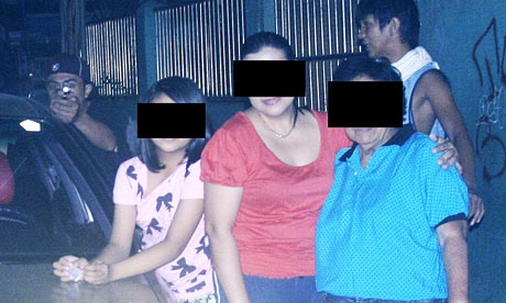 Reynaldo Dagsa's relatives pose for a picture, as a gunman pointing a pistol 