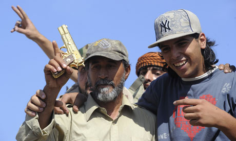 National Transitional Council fighters hold what they claim to be Gaddafi's gold-plated gun