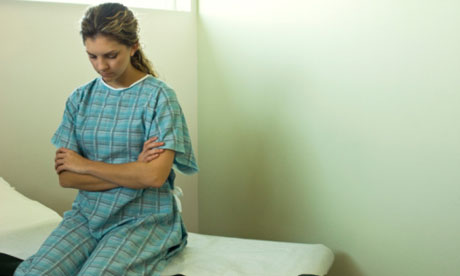 Patient sitting on examination table waiting for doctor