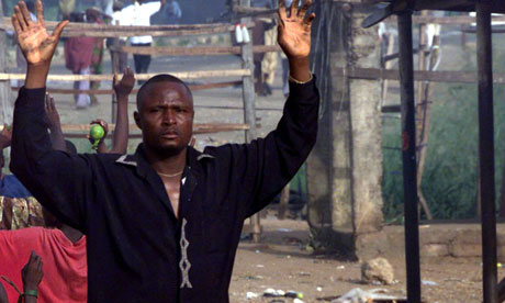 Nigerian civillian raises hands to soldiers 