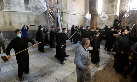 Armenian and Greek Orthodox clergy wielding brooms