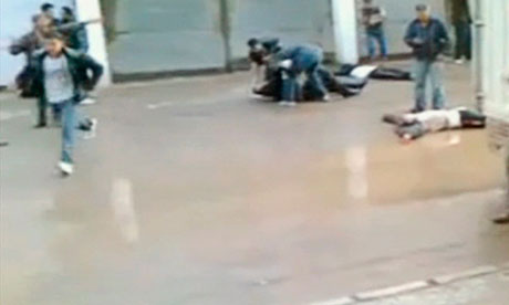 Protesters drag away a body