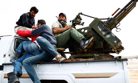 Libyan rebels flee artillery fire on the road between Ajdabiya and Brega