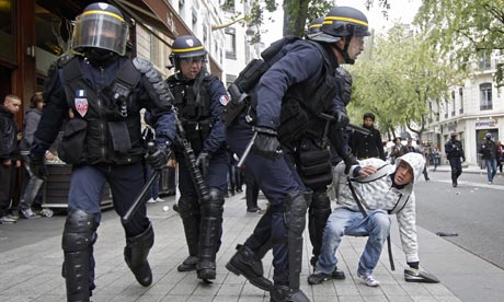 Riot police officers detain a youth during a student demonstration in Lyon 