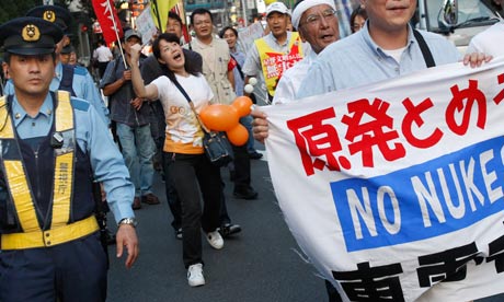 Demonstrators pass the headquarters of Tepco, the operator of Fukushima Daiichi nuclear plant