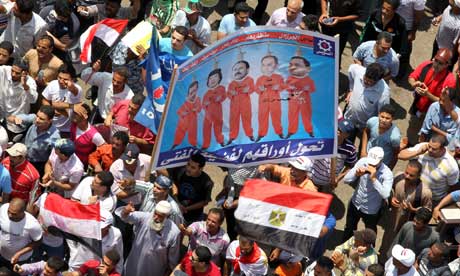 Egyptians display a placard depicting presidents