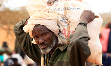 MDG : Somalia / Refugee carries a bag of relief food