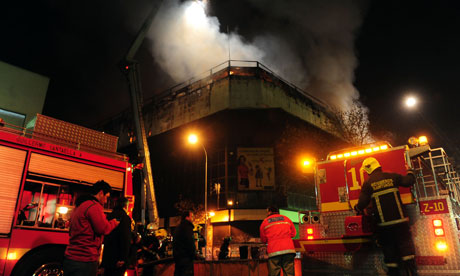 Firefighters battle a blaze in a store in Santiago