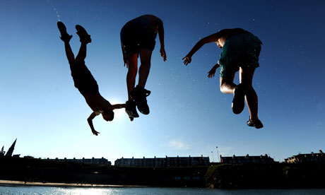 Young men jump into the sea in Cullercoats, North Tyneside