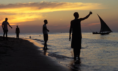 Backpackers watch the sunset at the beach