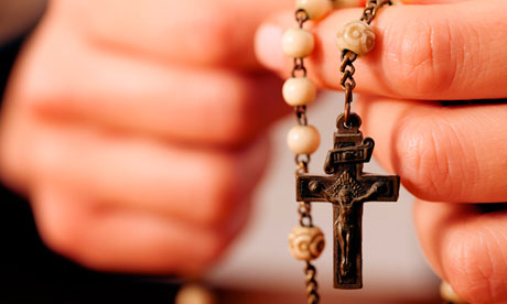 Woman with rosary sending a prayer to God, the dark setting suggests she is sad or lonely