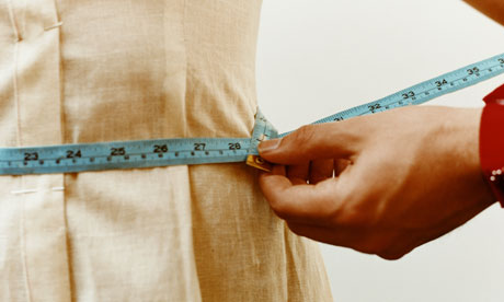 Measuring woman's waist with tape measure