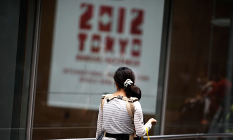A woman walks by the venue of the annual IMF meeting, in Tokyo.