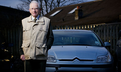 man standing beside a car
