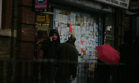 A newsagents window with adverts for rooms to rent in Newham, east London.