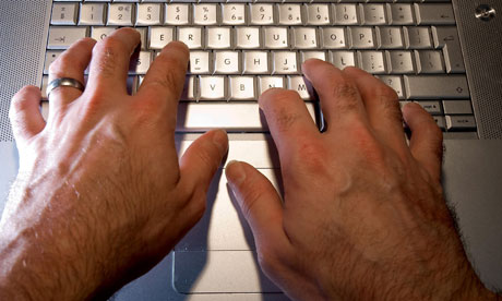 Man types on computer keyboard