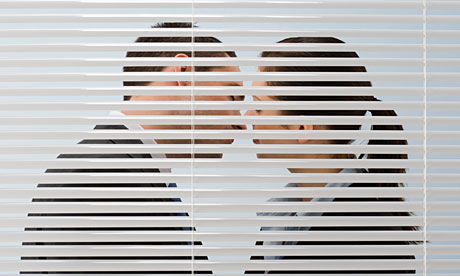 two adults kissing behind blinds