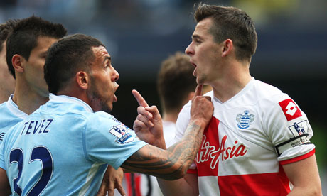 Queens Park Rangers' Joey Barton clashes with Manchester City's Carlos Tevez