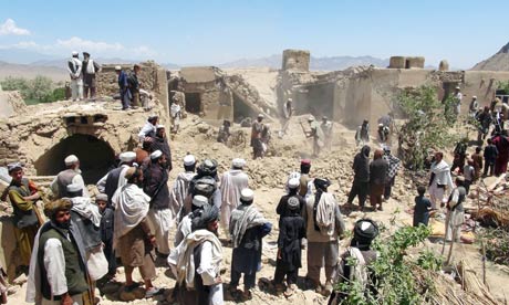 Afghan villagers gather at a house destroyed in a Nato raid in Logar province.