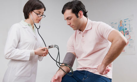 Female doctor checking man's blood pressure