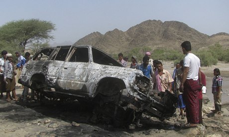 People gather at the site of a drone strike in southern Yemen