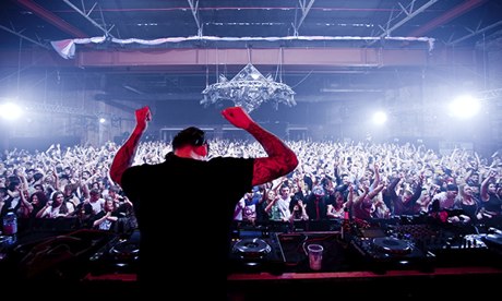 crowd of clubbers from behind the DJ's decks