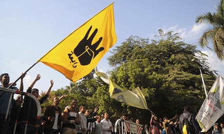Students of Cairo University, who are supporters of the Morsi, wave a flag bearing the Rabaa sign