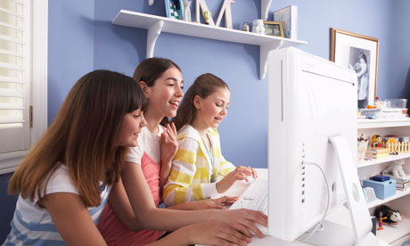 Young girls gather around computer 