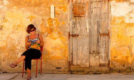 woman reading lonely planet guidebook