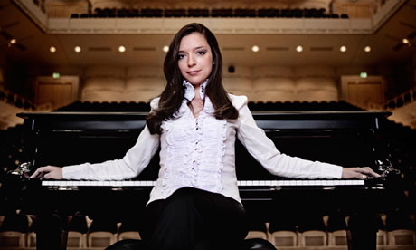 Yulianna Avdeeva in front of a piano in an empty concert hall