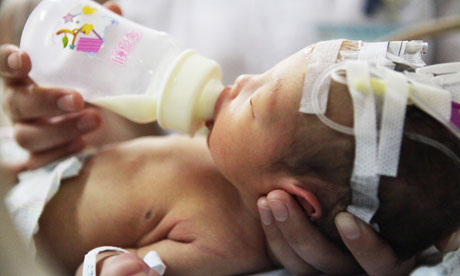 A nurse feeds Baby 59, who is now stable in hospital after being rescued from a sewer pipe.