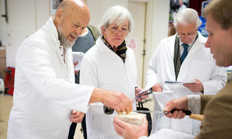 Michael Eavis in white coat helps judge cheese at the Royal Bath and West show