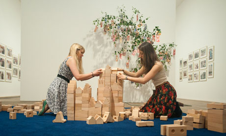 Meschac Gaba's installation: two women creating a tower with building blocks
