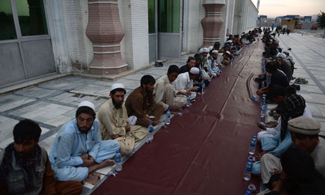 Afghan men wait for their free evening m