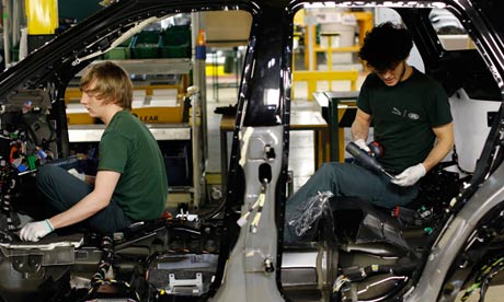 Two workers inside the body shell of a Range Rover Evoque SUV