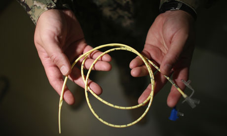 Doctor holds a tube used to force-feed hunger strikers at Guantánamo Bay