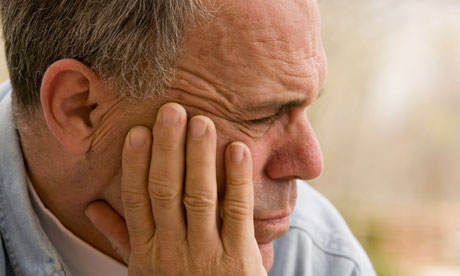 Older mature man worrying with hand to face.
