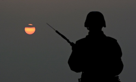 Soldiers stand guard during sunset
