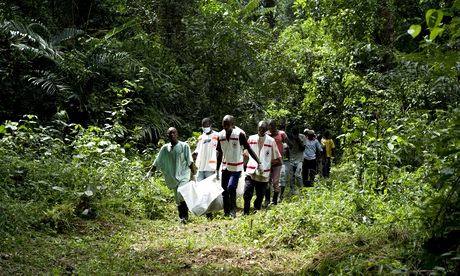 Health workers in Guinea carry the body of a victim of Ebola for burial