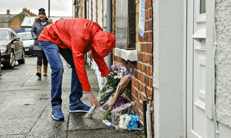 A man lays flowers outside the Matthew Goddard's home in East Belfast