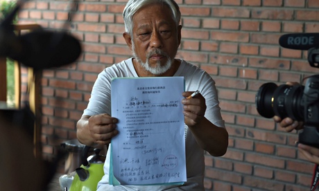 Li Xianting, Beijing independent film festival organiser, holds document up to the cameras