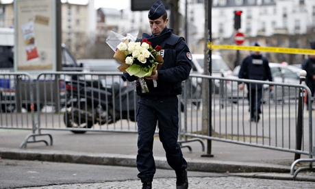 TOPSHOTS A policeman carries flowers bro