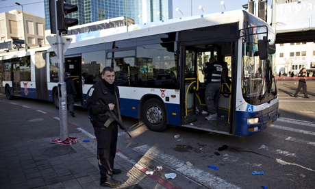 An Israeli police officer secures the scene after a suspected terrorist attack on a bus in Tel Aviv