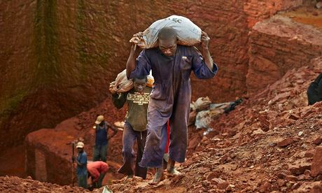 Diamond miners carry bags of earth from their concession near an Angolan village