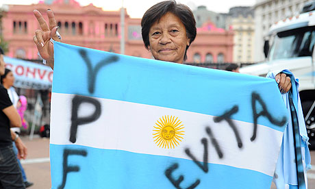 A woman holds an Argentinian flag at the presidential palace