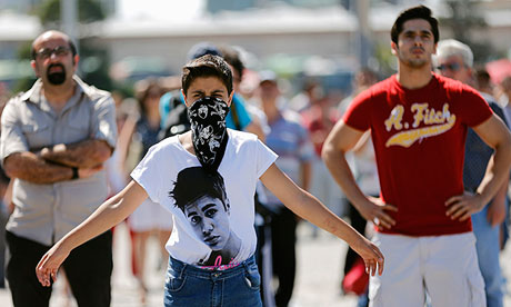 People stand in silent protest at Taksim Square after a man's silent vigil inspired copycat protests