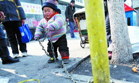 A 2 year old Chinese boy is chained to a post on roadside
